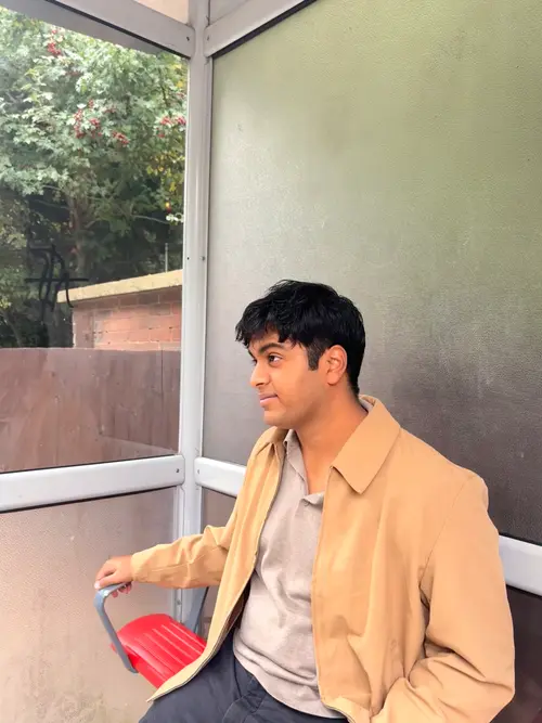Dev seated at a bus stop